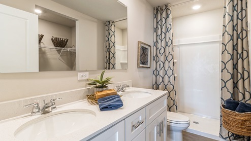 primary bathroom with dual sinks and white cabinetry
