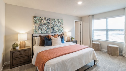 primary bedroom with white queen bed and two wood nightstands