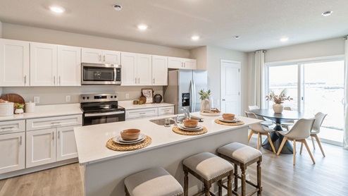 modern kitchen and dining area with white cabinets and island