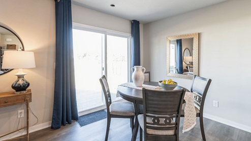small dining area with wood dining table and chairs next to sliding glass doors