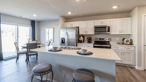 kitchen with white cabinetry and island with quartz countertops