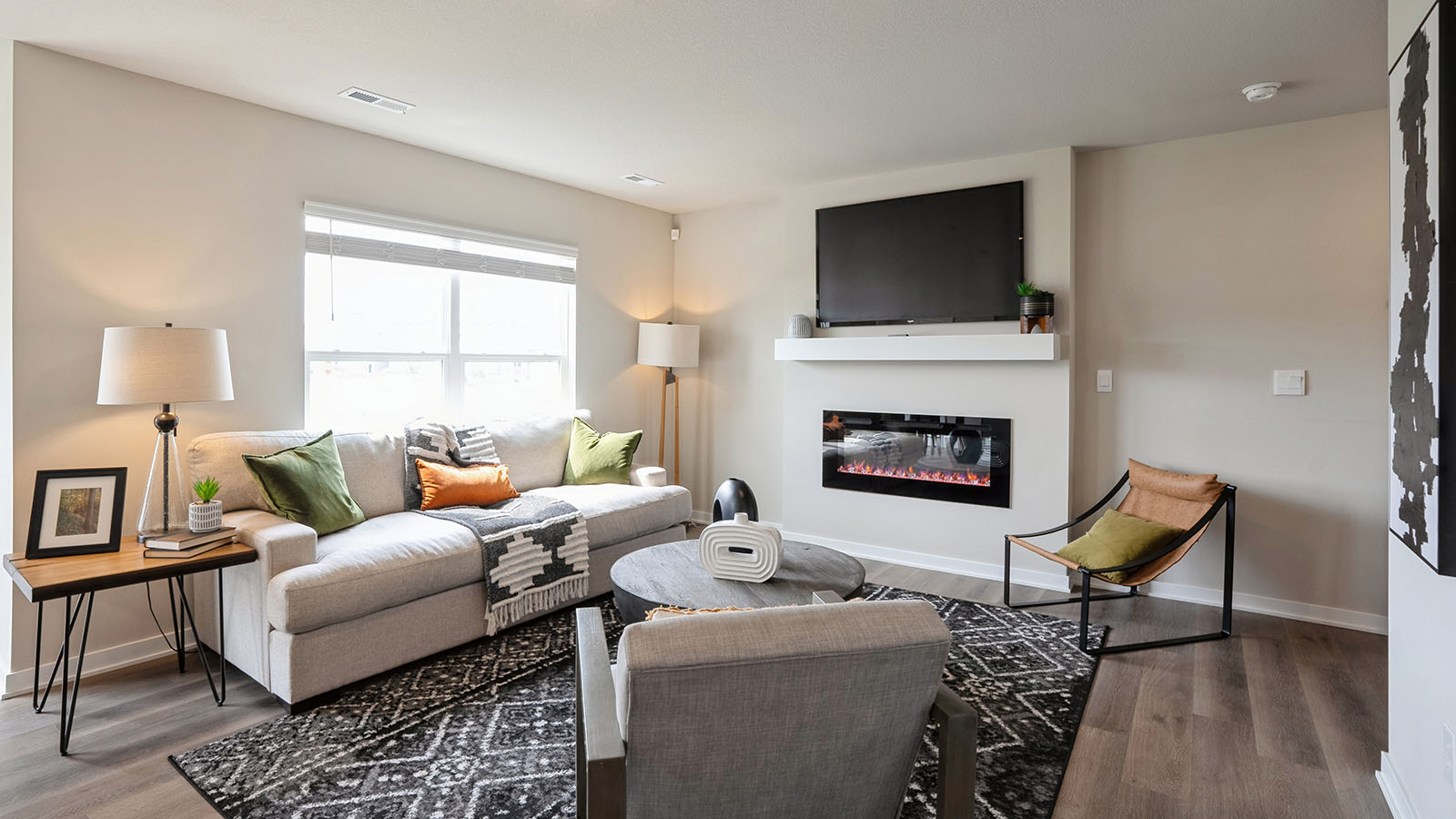 Bright and spacious living room with large window and electric fireplace