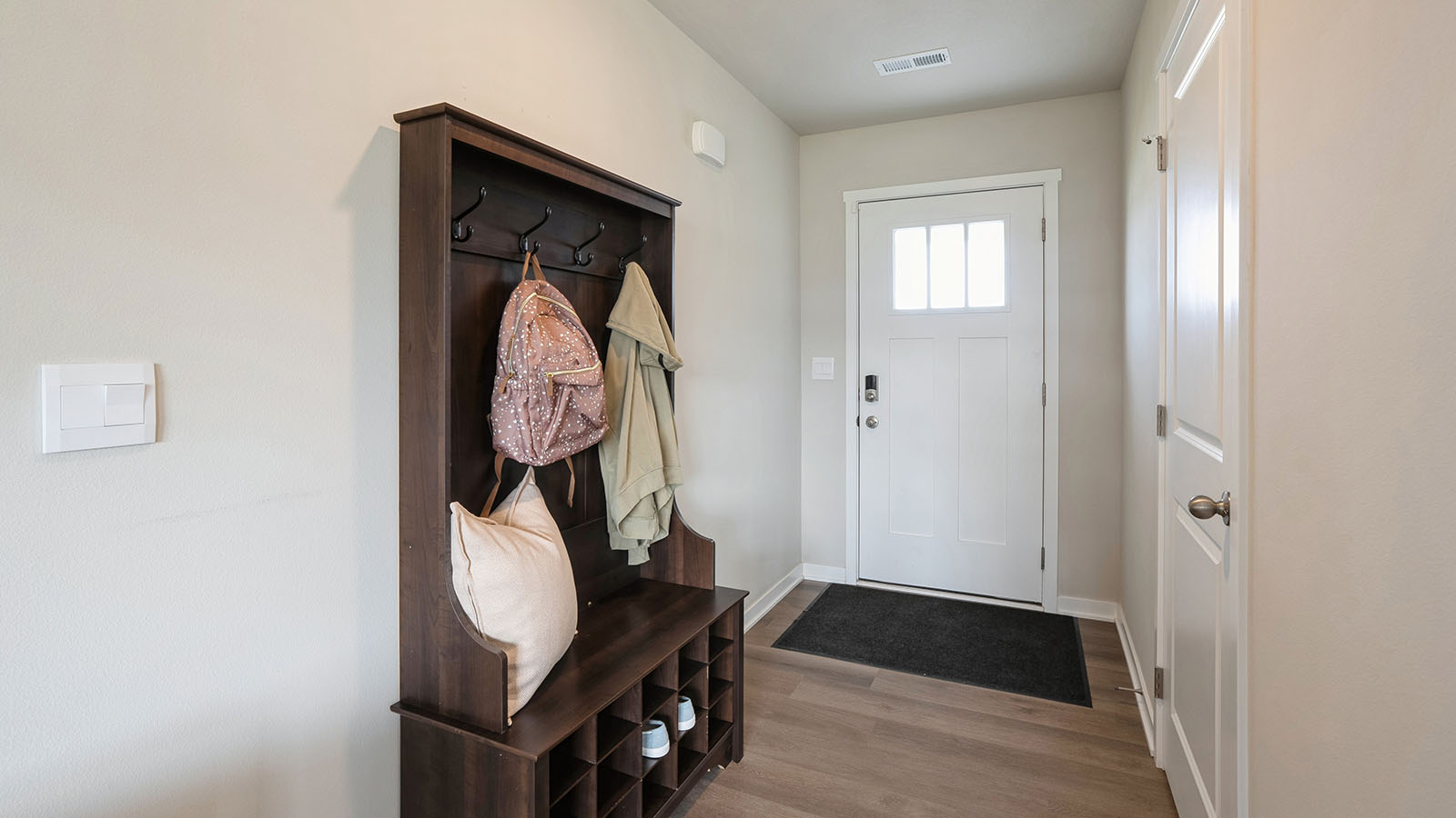 Front entryway with wood hall tree that provides lots of storage