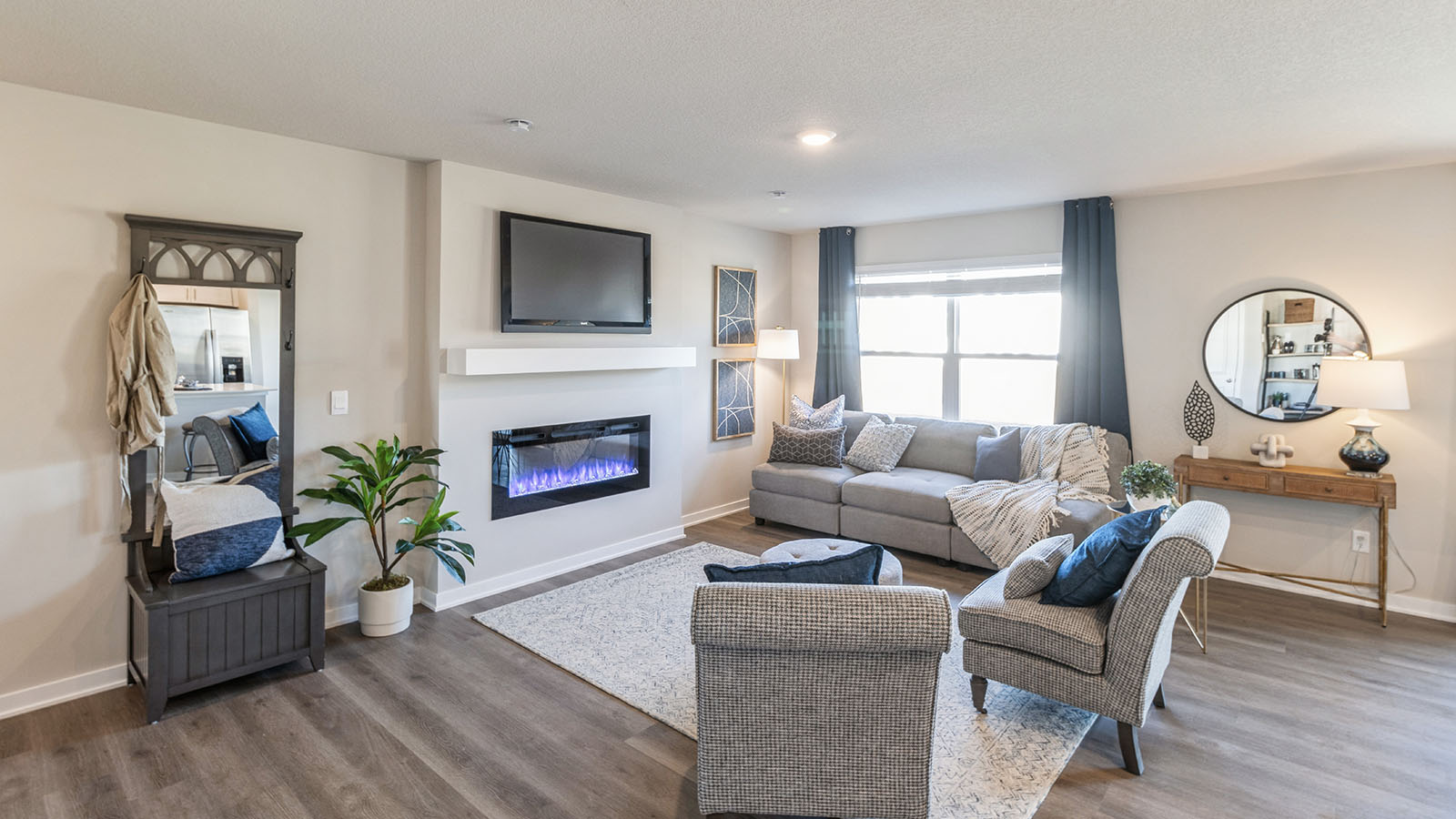Living room with brown flooring and white walls.