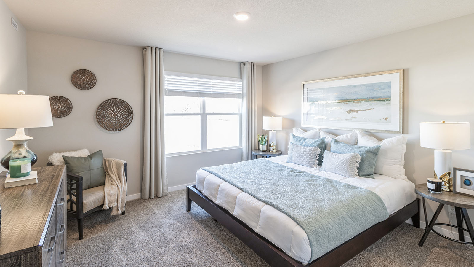 Bedroom with a large window and carpeted floors.