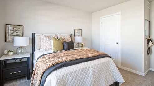 First bedroom with large white bed with nightstands and closet