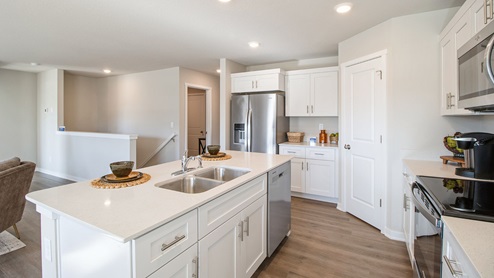 Large modern kitchen with walk-in pantry and island with quartz countertops