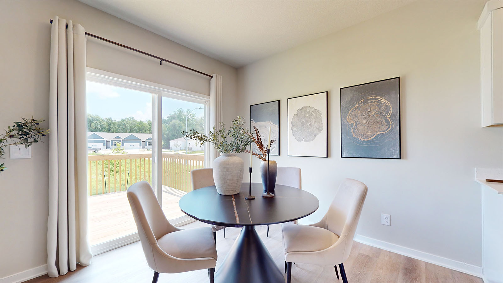 Dining area with black table and white chairs next to sliding glass doors