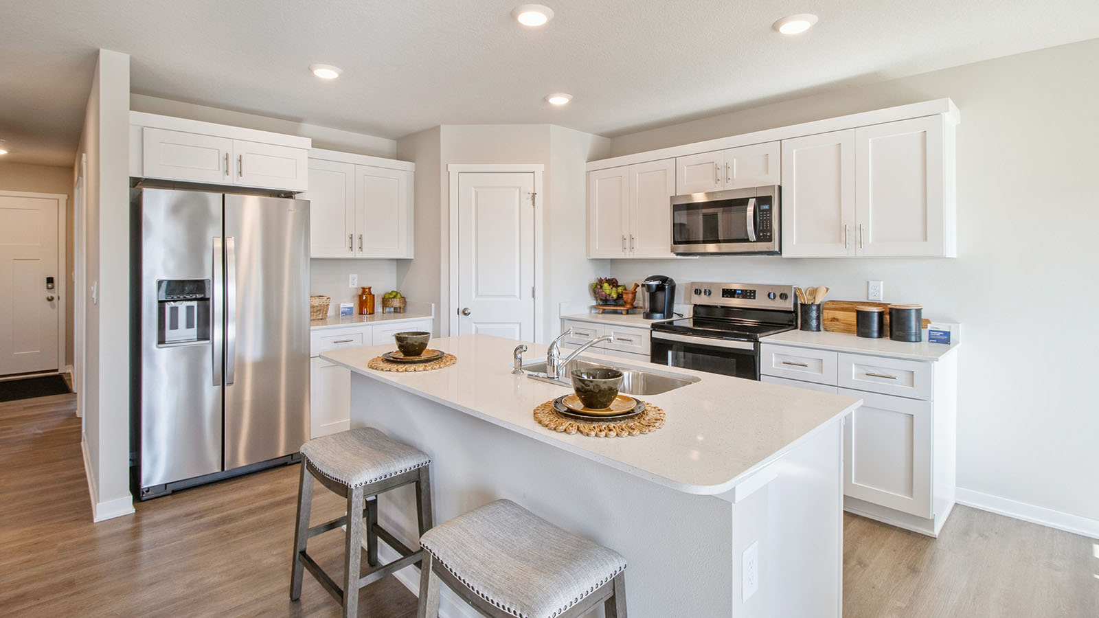 Bright kitchen with stainless-steel appliances and a large kitchen island with barstools