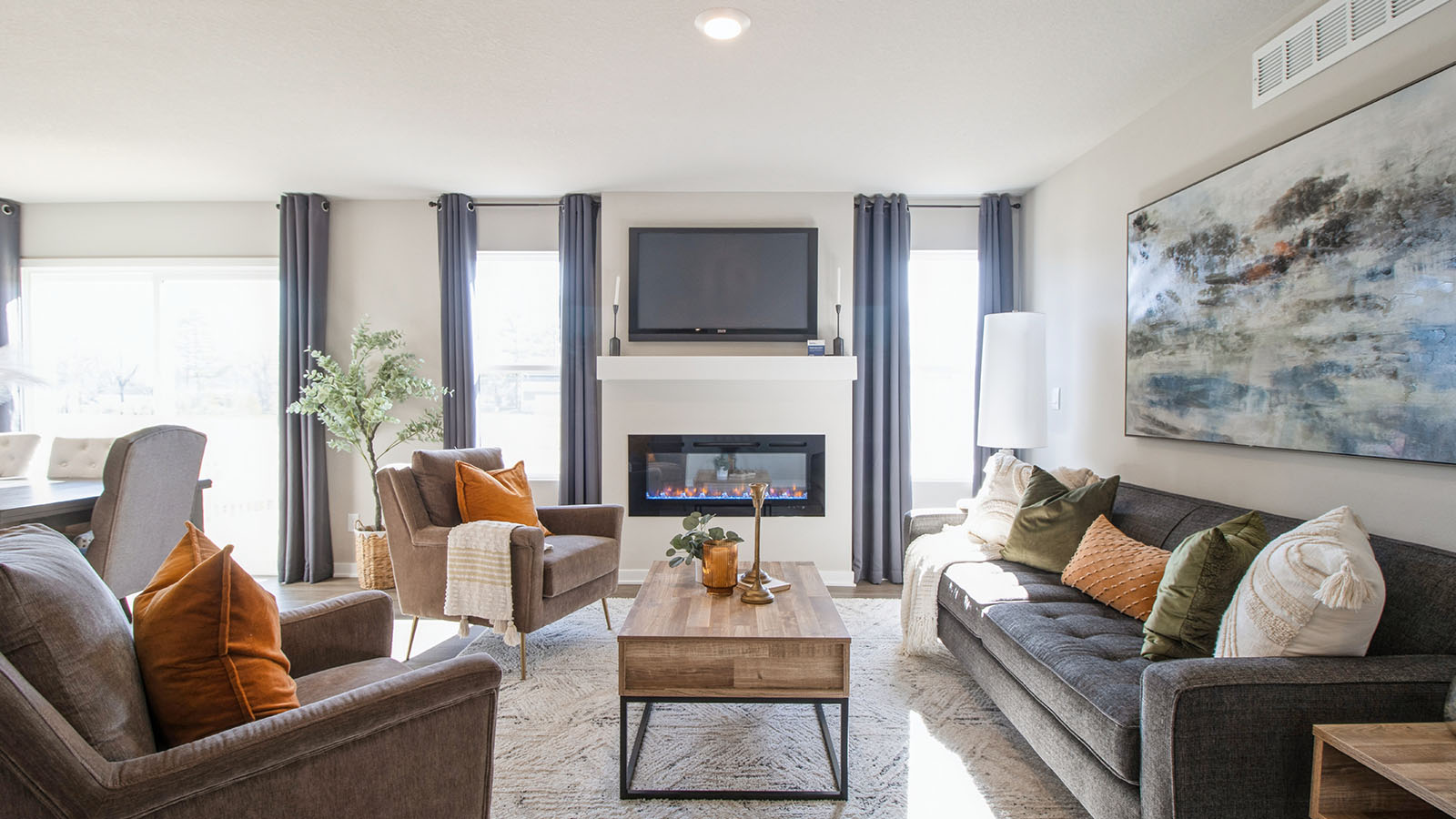 Spacious living room with two small windows and electric fireplace