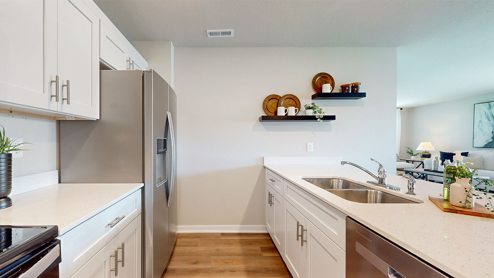 Kitchen with floating shelves and stainless steel appliances.