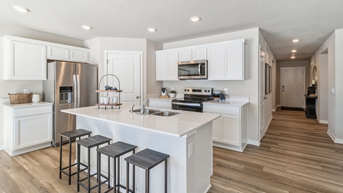 Modern white kitchen with quartz countertops and island