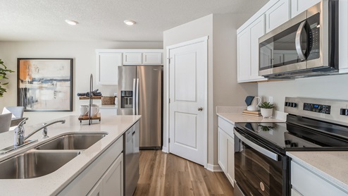 side view of kitchen with stainless-steel appliances and quartz countertops