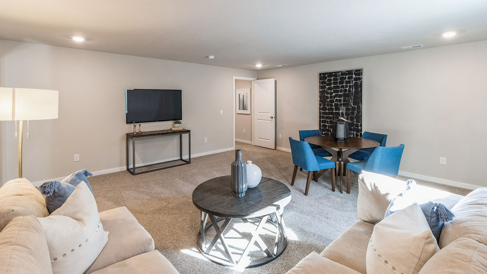 Finished basement with small coffee table and dining table with chairs
