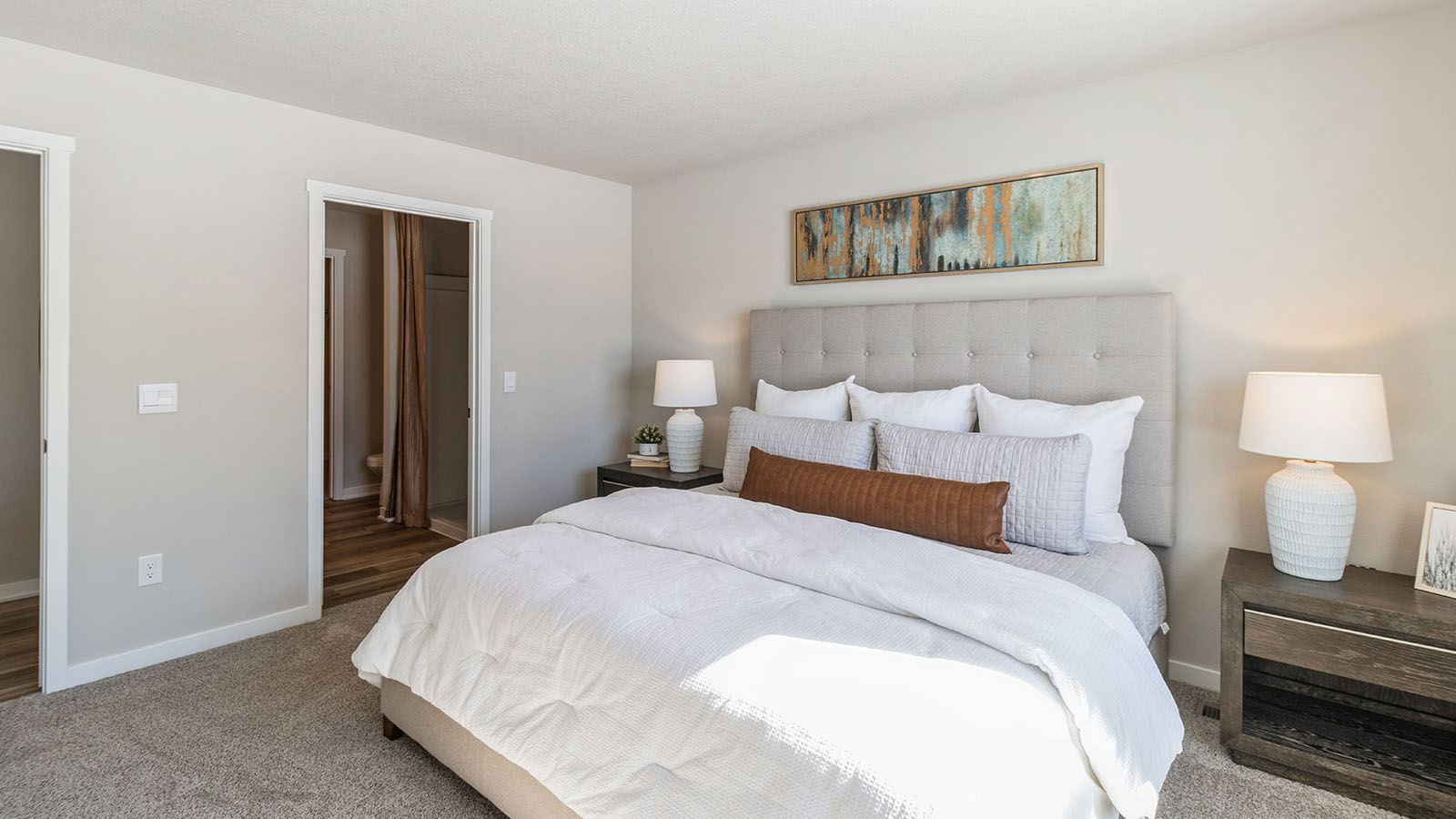 Primary bedroom with bed and nightstands with view of primary bathroom