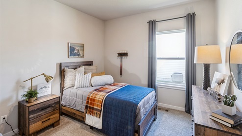 Third bedroom with colorful bed and small window