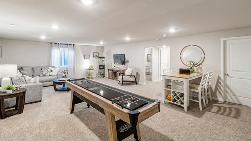 Finished basement with table and chairs and egress window