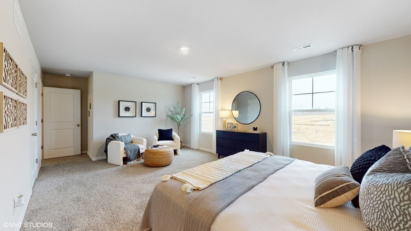 primary bedroom with dresser and chair as well as bed