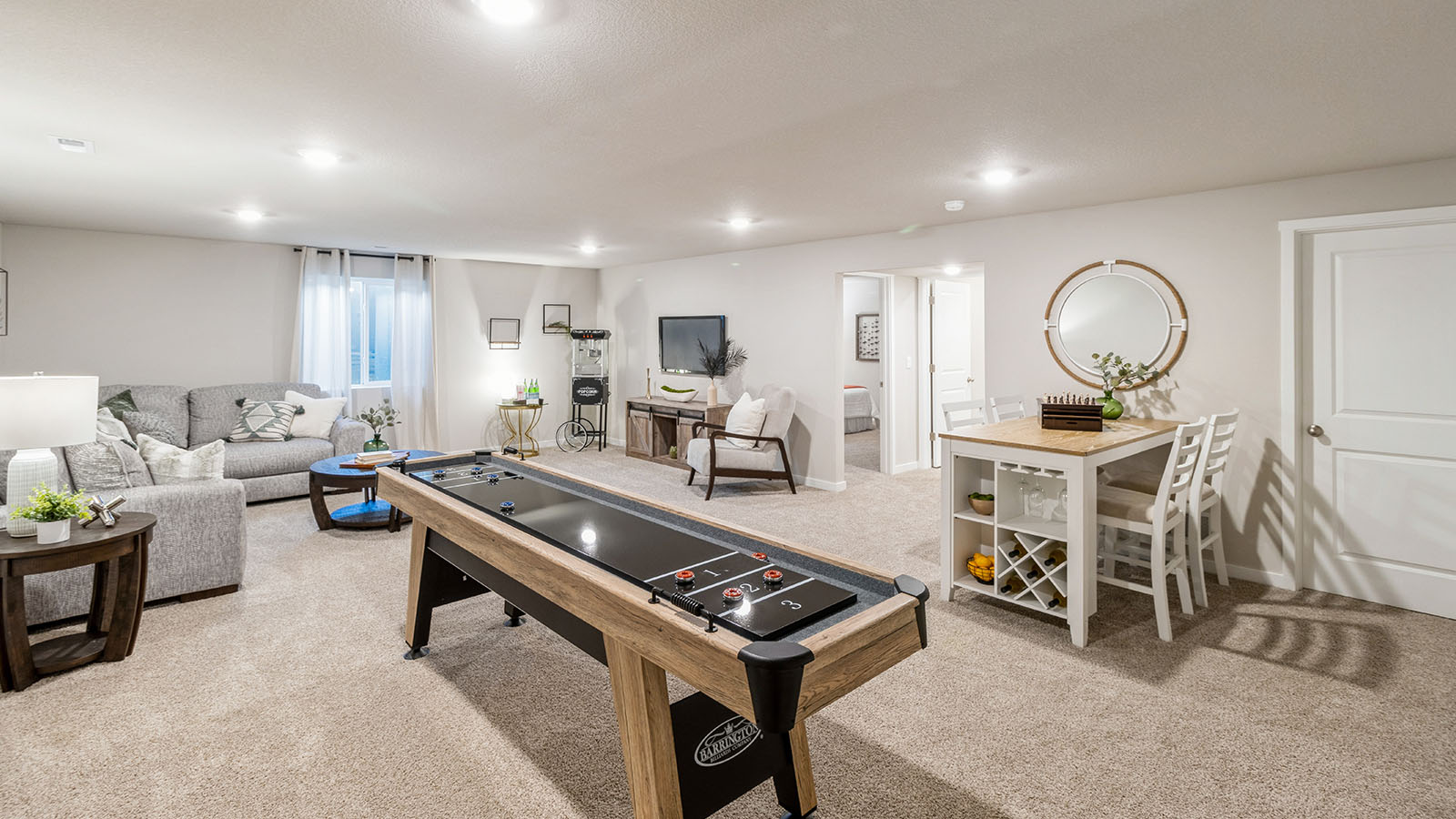 Finished basement with space fora setional and shuffle board table.