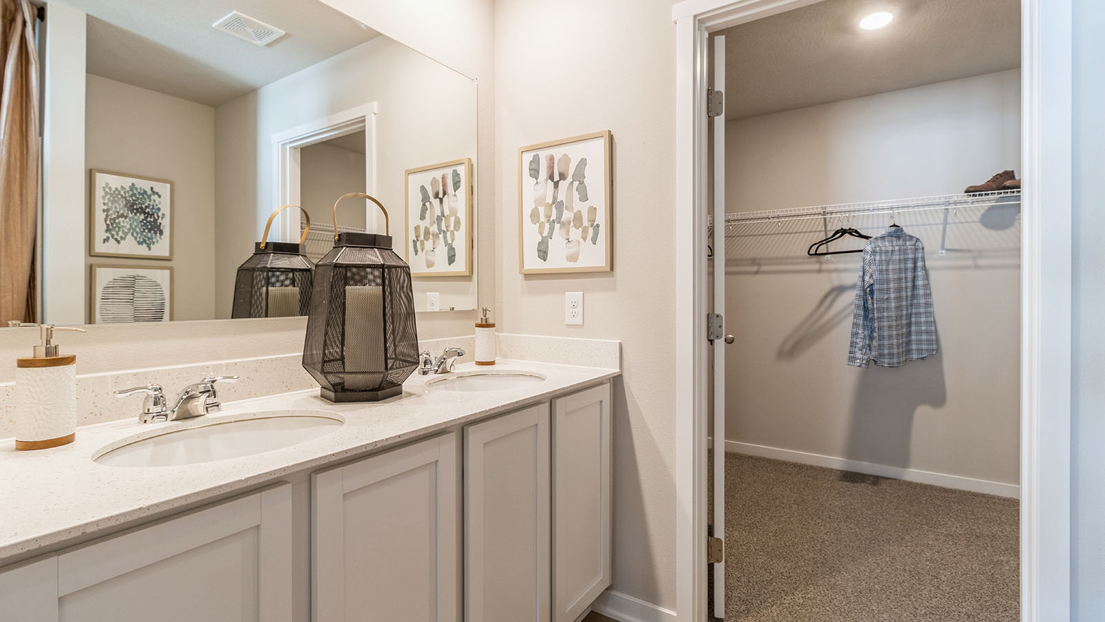 Primary bathroom with large mirror and white cabinetry