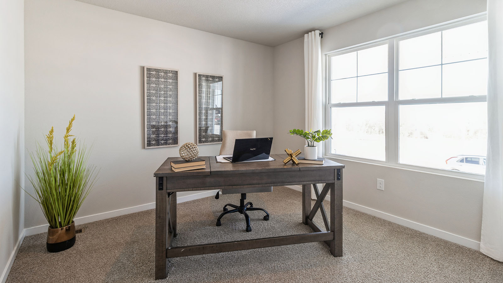First bedroom staged as an office with large window and desk with chair