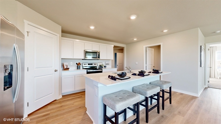 Functional kitchen island adds a sink, multi-prep zones, cabintes and a pantry, new appliance suite, and outside access