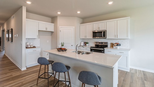 White modern kitchen with quartz countertops and island