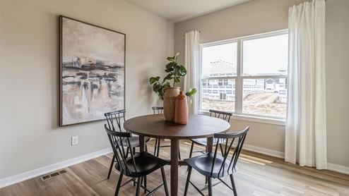 Dining room with black table and chairs next to large window