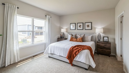 Primary bedroom with large white bed and two wood nightstands