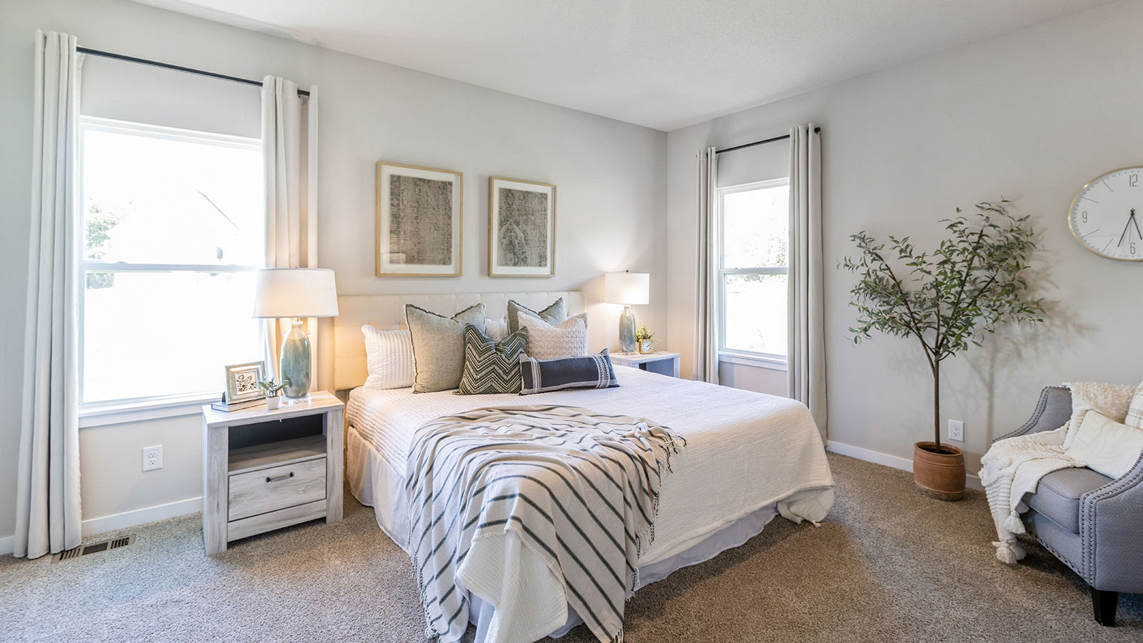 Primary bedroom with two windows and large bed