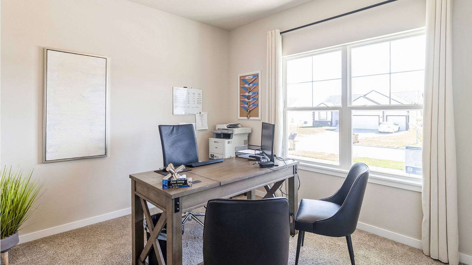 Second bedroom staged as an office with desk and chairs