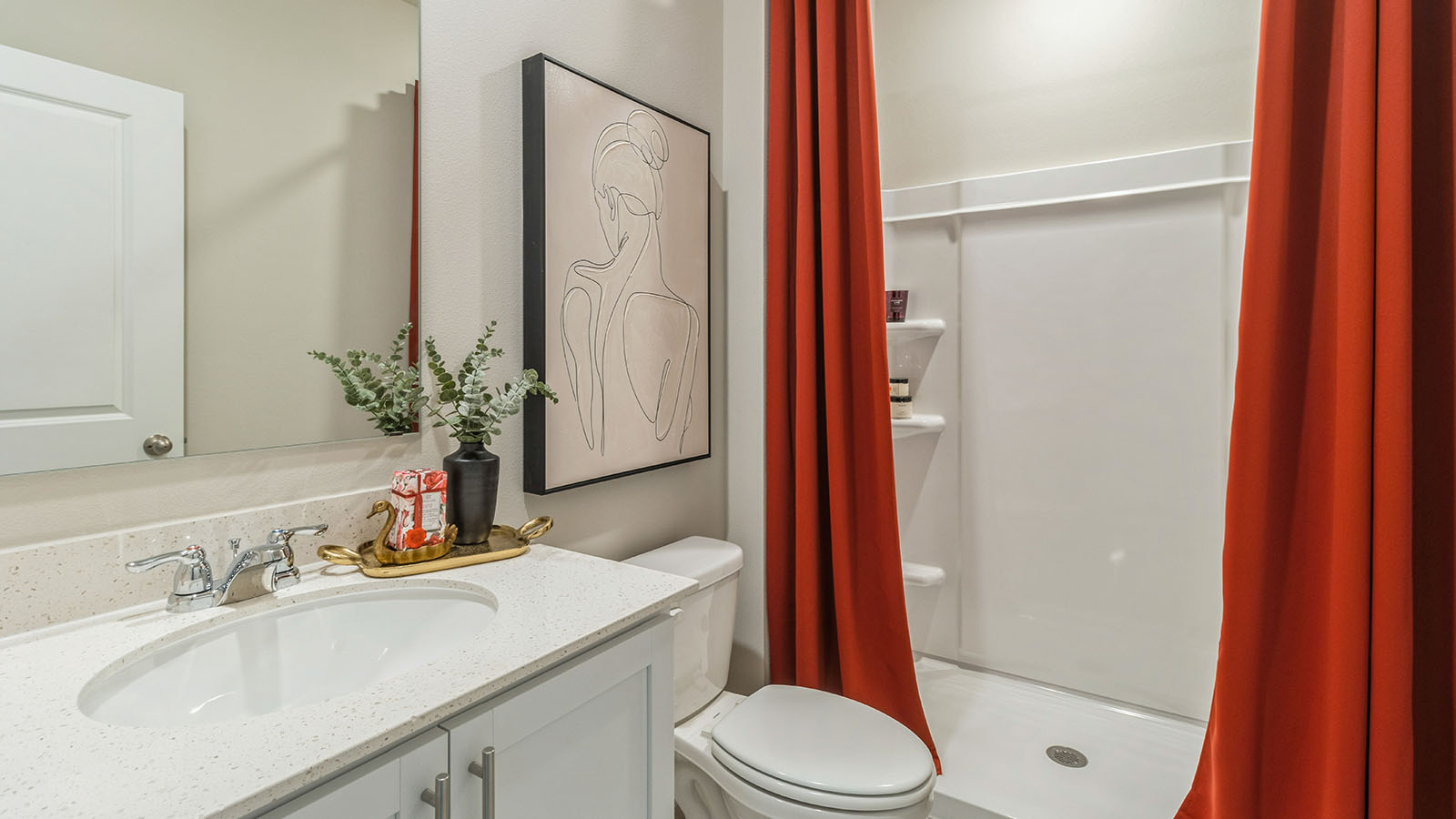 First bathroom with sink and white cabinets and shower