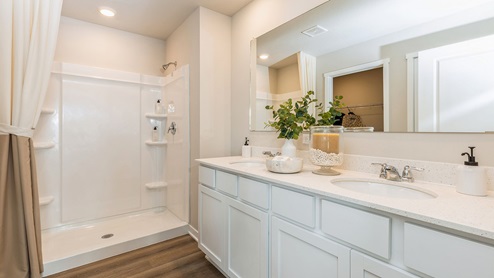 primary bathroom with dual sinks and large mirror