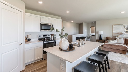 Spacious kitchen with white cabinetry and quartz countertops