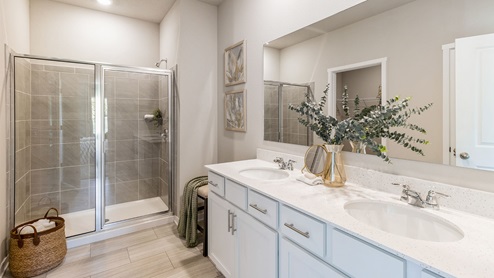 Primary bathroom with glass shower doors and dual sinks