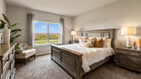 Primary bedroom with large window and white bed