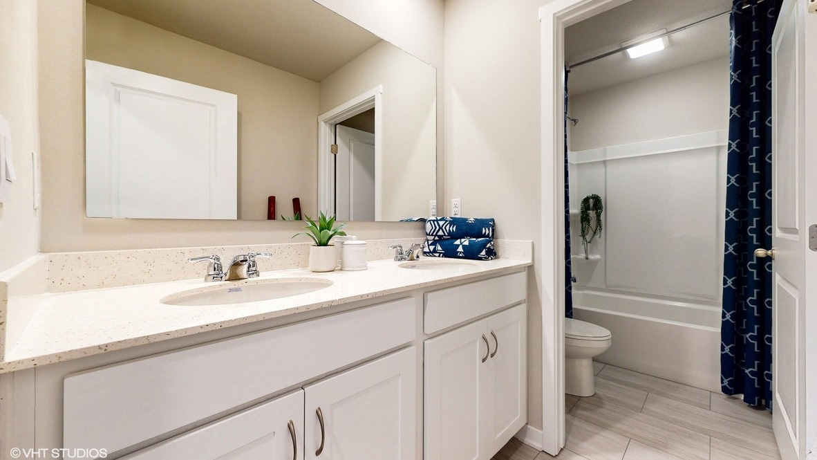 First bathroom with large mirror and bathtub
