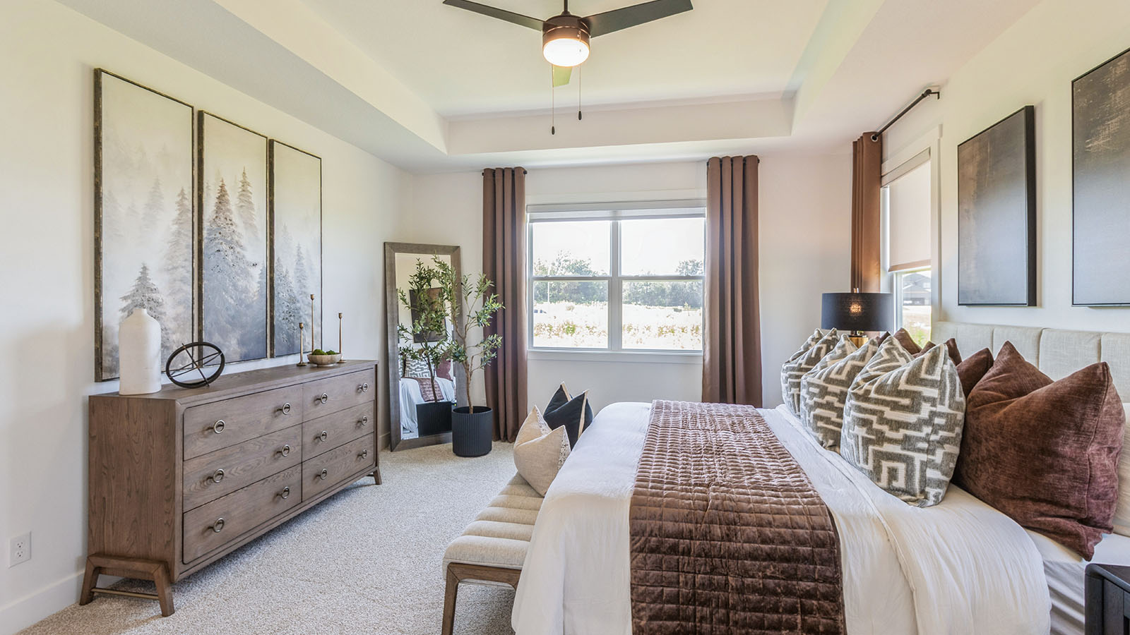 Primary bedroom with bed and wood dresser and wall art