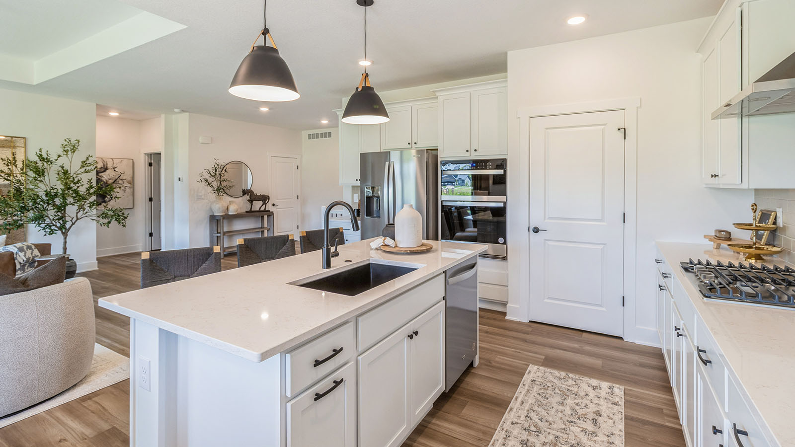 Side view of kitchen with white cabinets and large black farmhouse sink on island