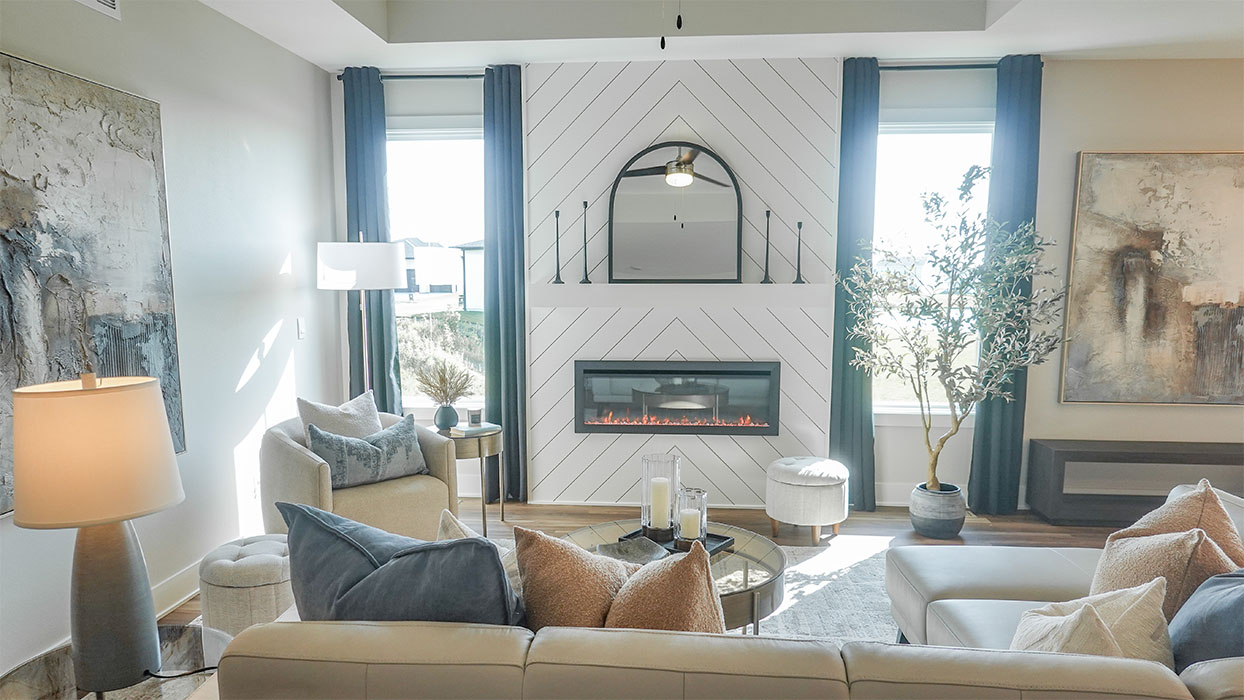 Spacious living room with brown flooring, white walls and windows