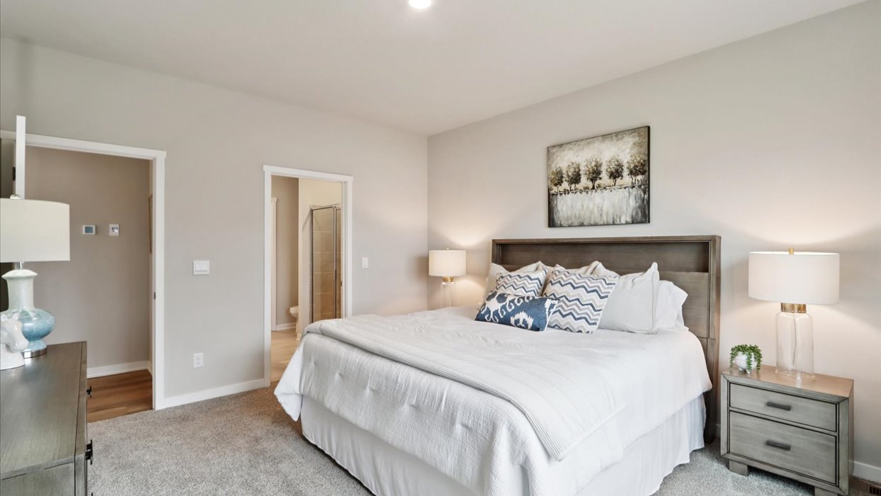 Spacious primary suite with natural light, attached bathroom, & walk in closet