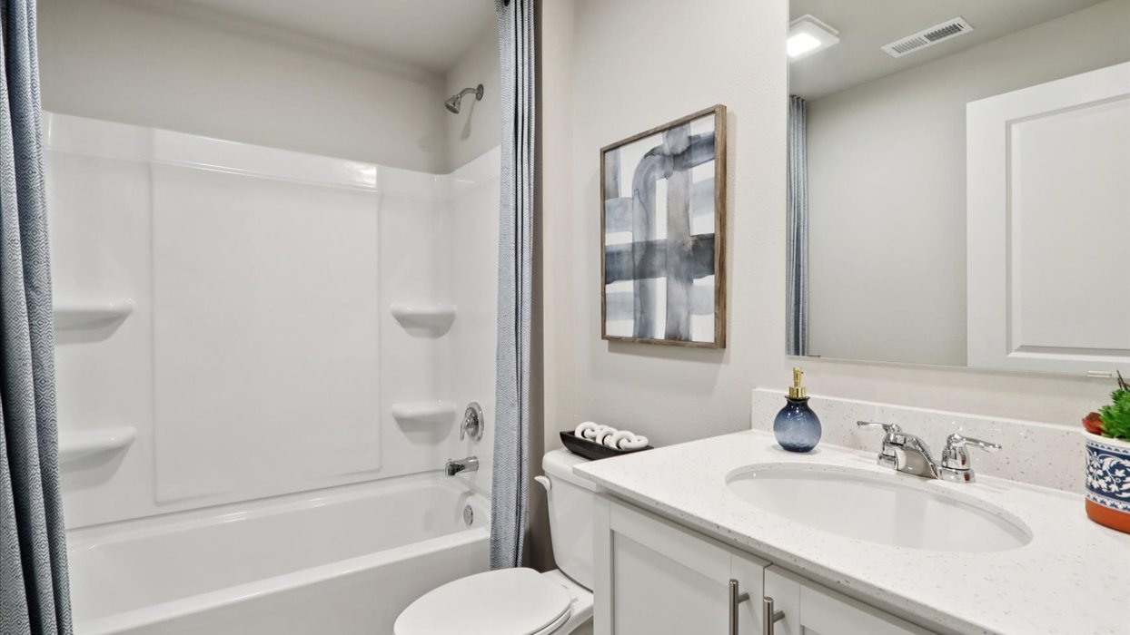 Bathroom with tub and shower combo, quartz countertops, and white vanity