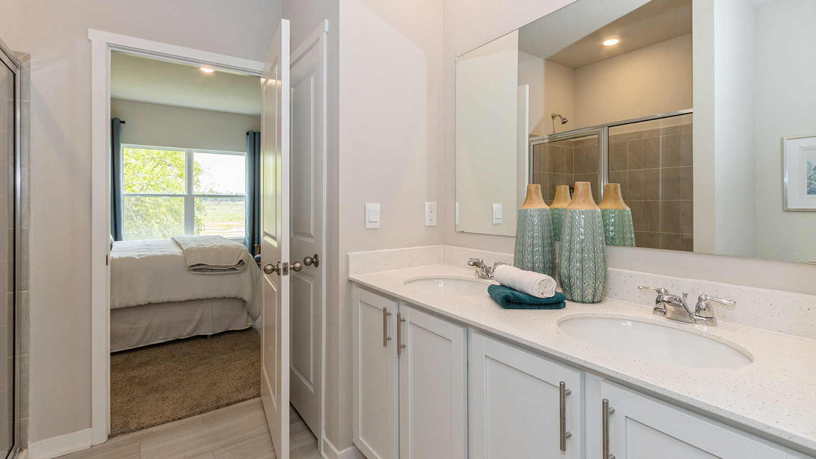 Spacious primary bathroom featuring dual vanities, modern fixtures, and a walk-in shower.