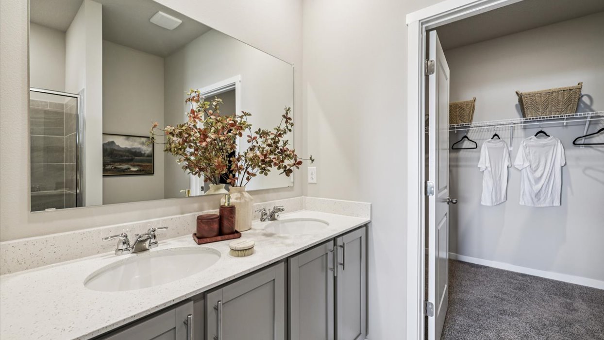 Spacious bathroom with white cabinetry and double sinks