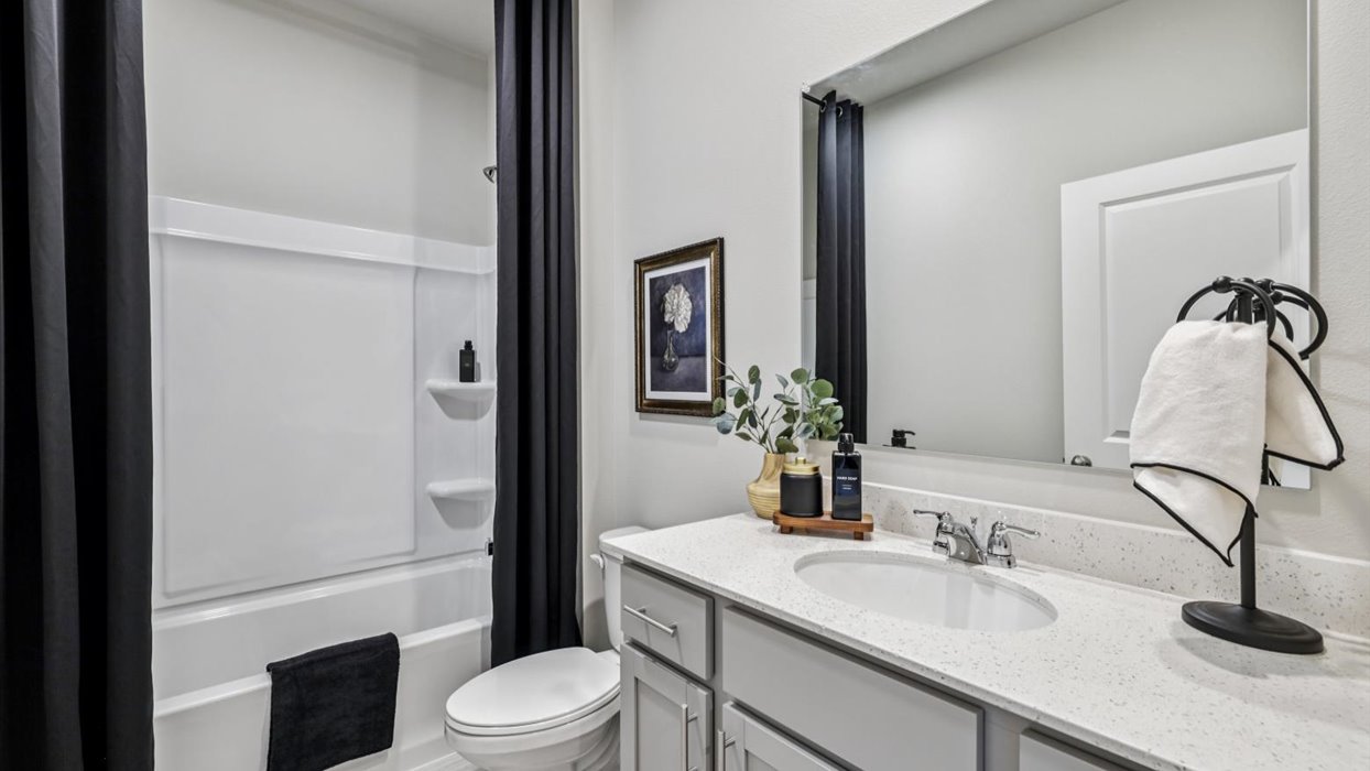 Bathroom with tub and shower combo, quartz countertops, and white vanity