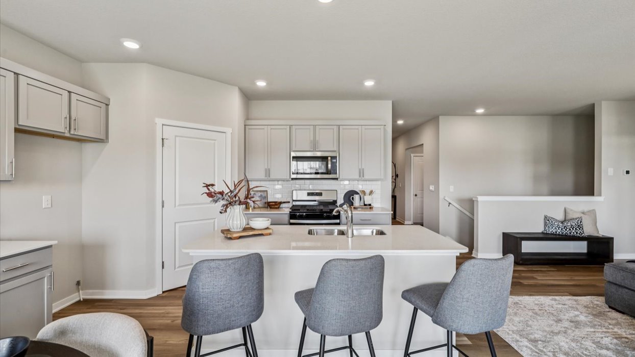Kitchen with stainless steel appliances, quartz countertops, and white cabinetry