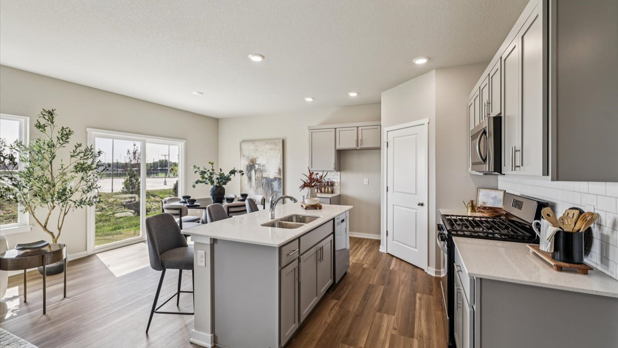 Kitchen with stainless steel appliances, quartz countertops, and white cabinetry
