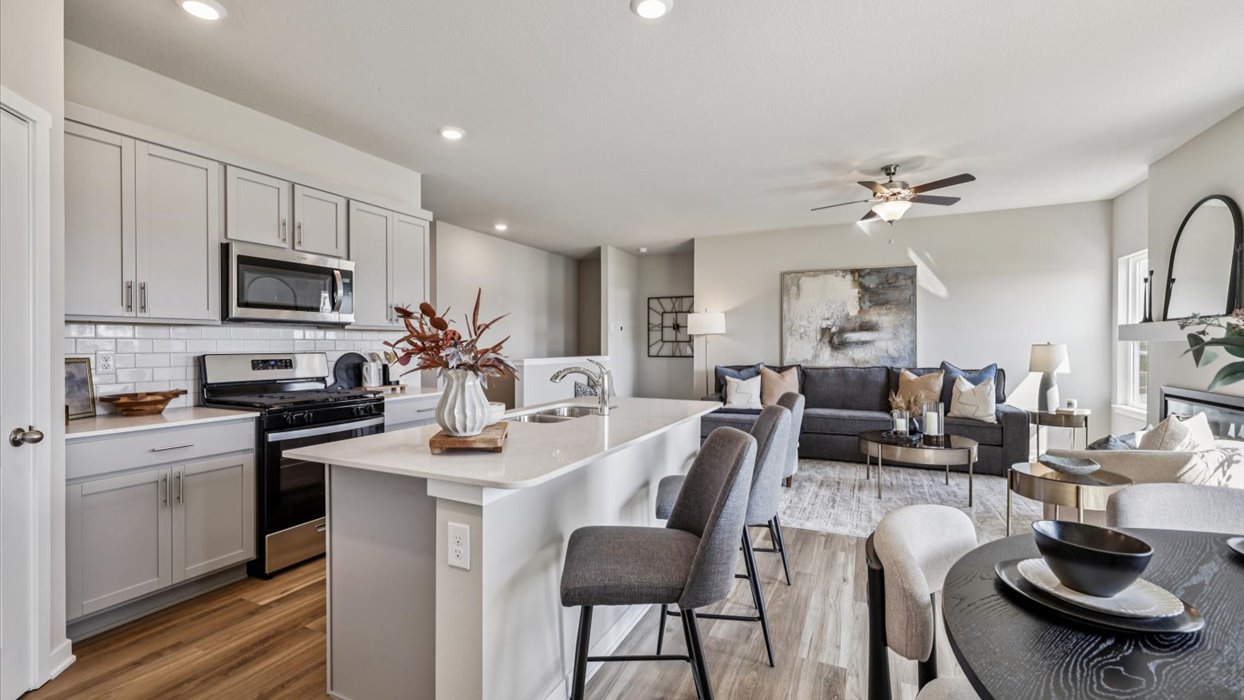 Kitchen with stainless steel appliances, quartz countertops, and white cabinetry