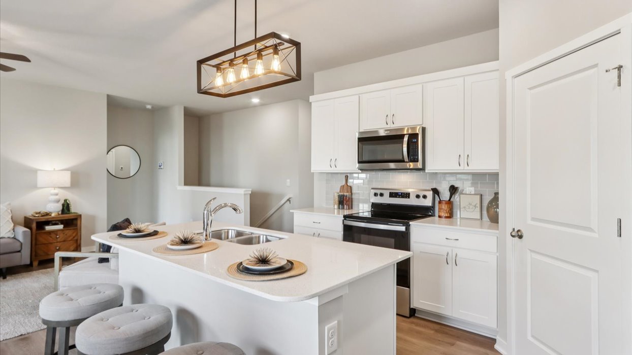 Kitchen with stainless steel appliances, quartz countertops, and white cabinetry