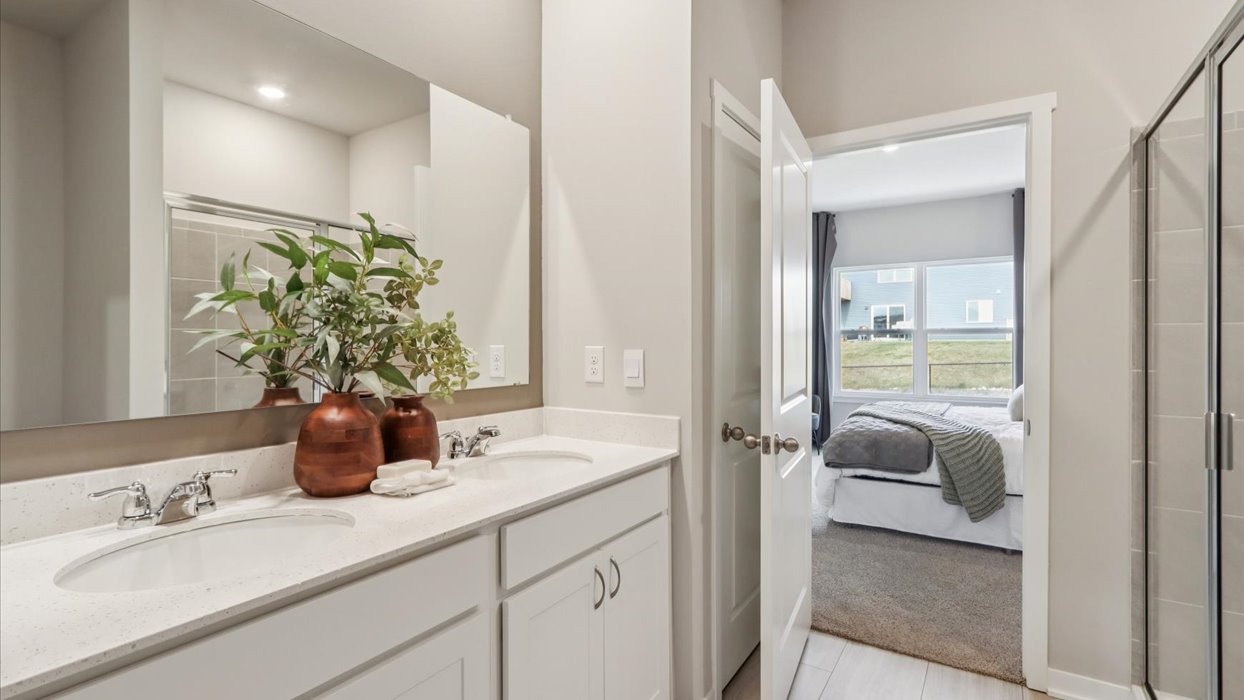 Spacious bathroom with white cabinetry and double sinks